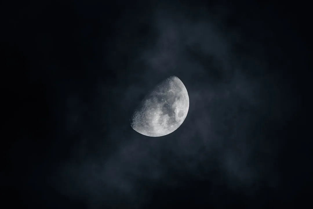 A crescent moon shines brightly in the night sky.