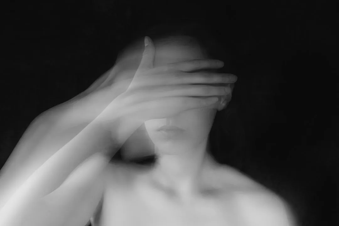 grayscale photo of topless woman covering her face with her hands