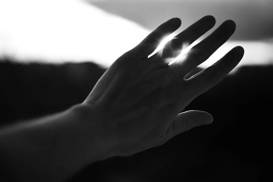 Hand silhouetted against the sun.