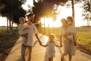 Family walking on path with trees at sunset