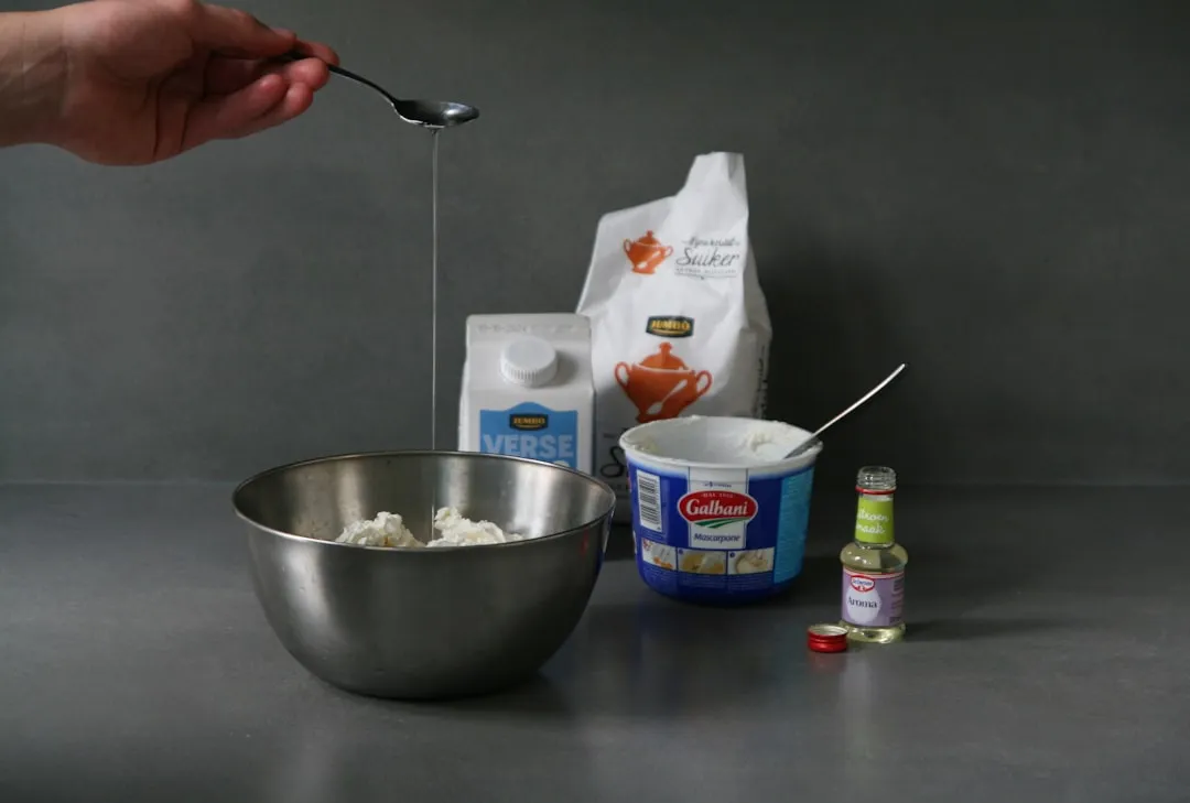 A person mixing ingredients in a bowl with a spoon