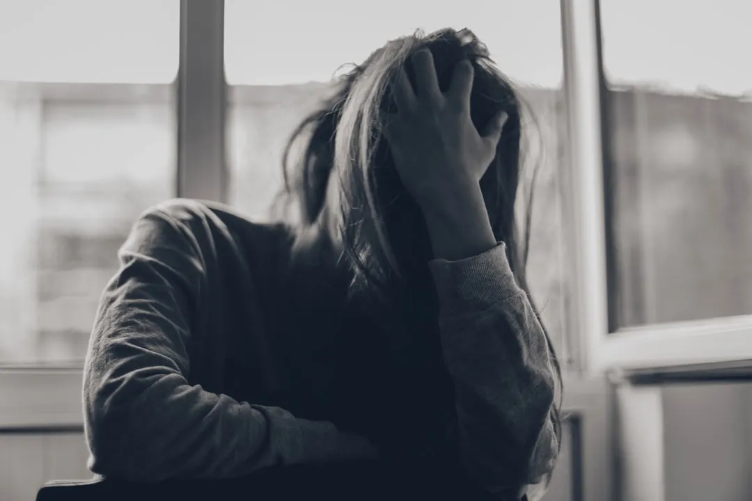 grayscale photography of person covering face