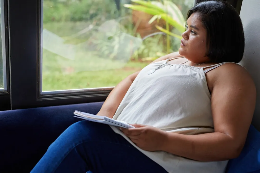 A woman looks out the window, deep in thought.