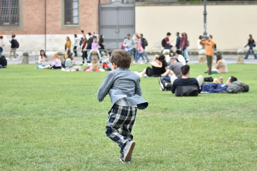 A young boy running across a lush green field