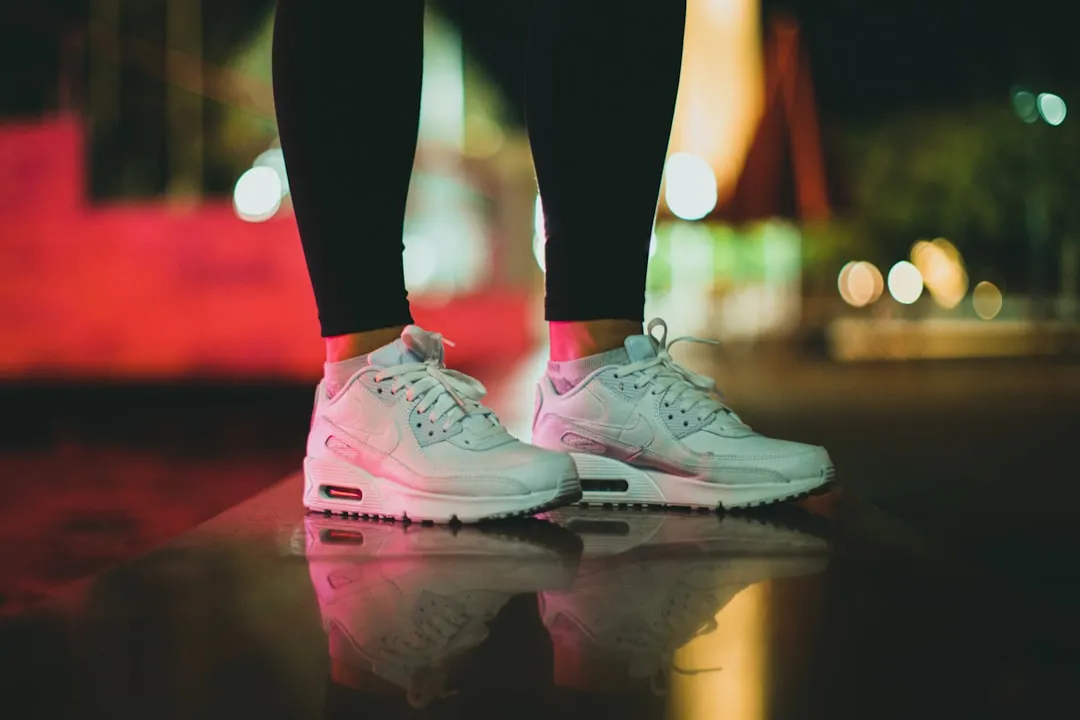 a person standing on a reflective surface wearing white sneakers