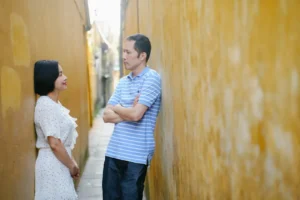 a man and a woman standing next to a wall
