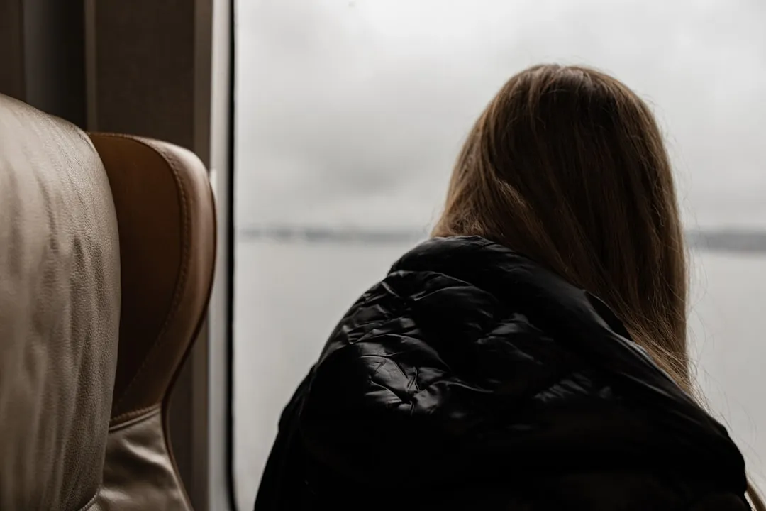 a woman sitting on a train looking out the window