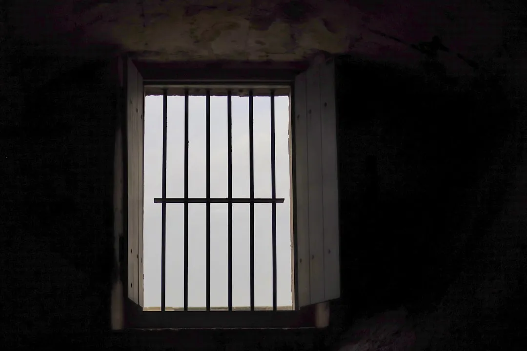 a jail cell with bars on the top of it
