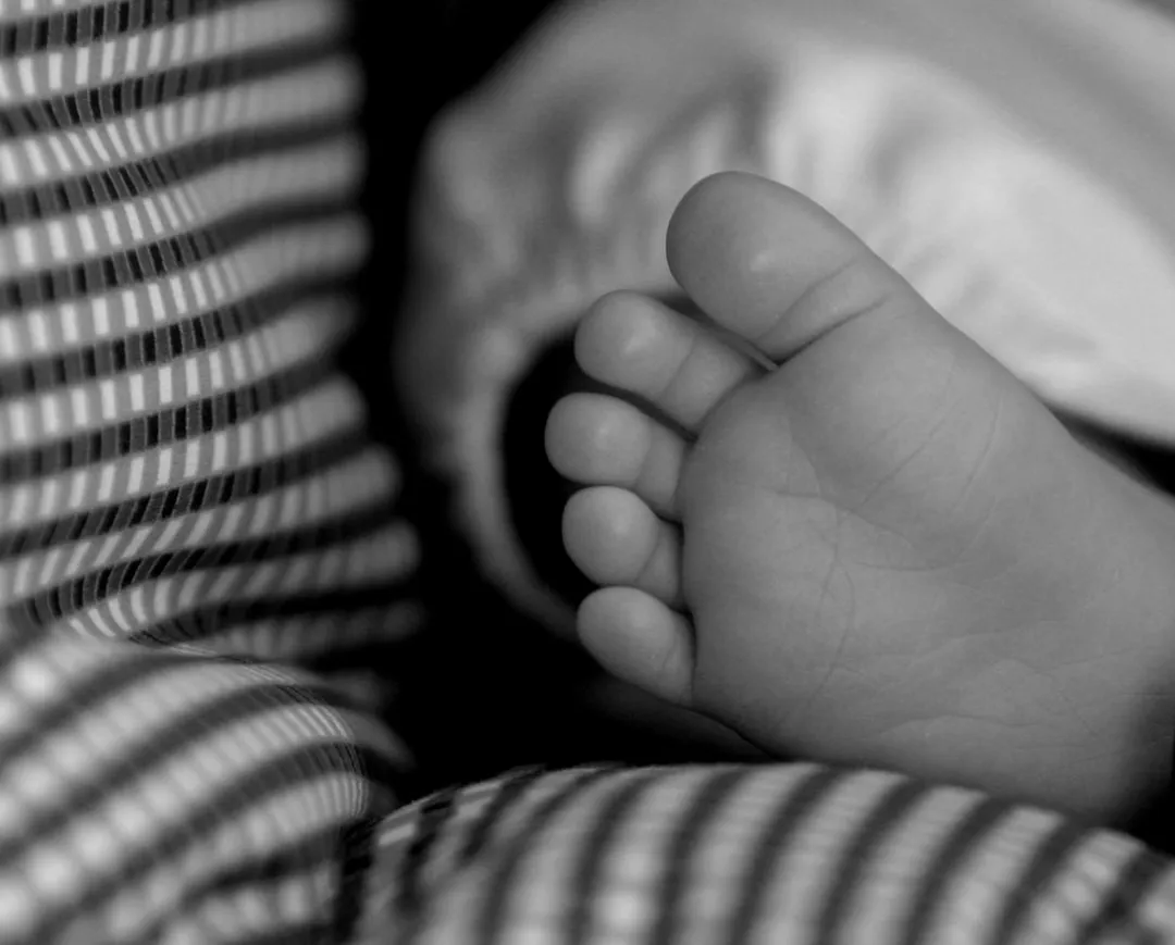 a black and white photo of a baby's foot