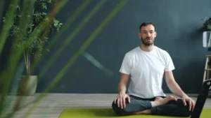 Man meditating in lotus pose on yoga mat