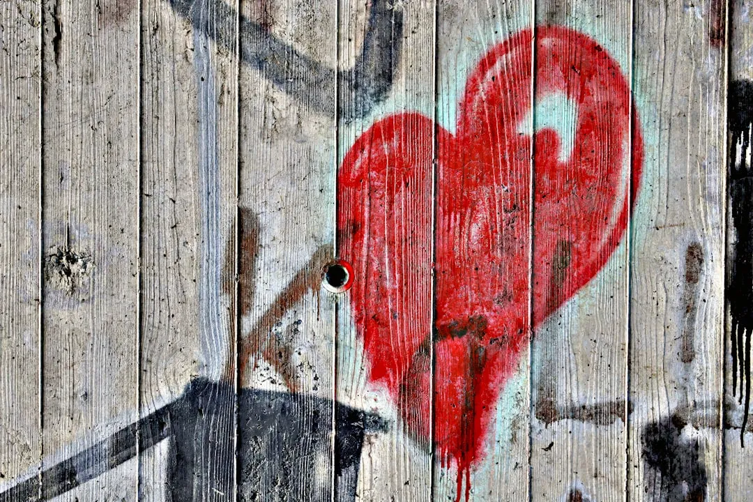 A red heart graffiti on a wooden wall