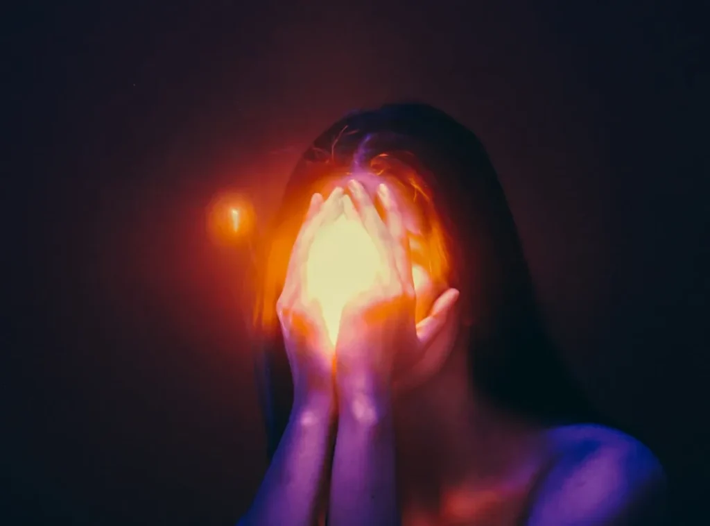 A woman covering her face with her hands