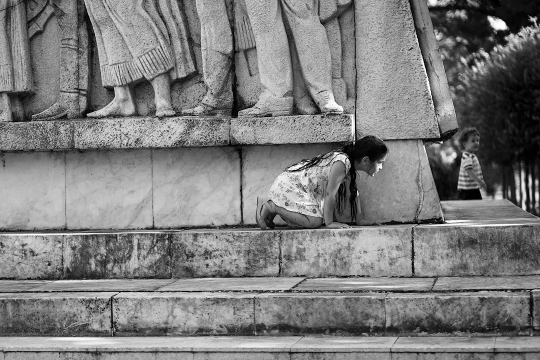 a person kneeling down next to a statue
