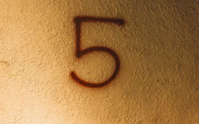 A red number five spray-painted on a wall