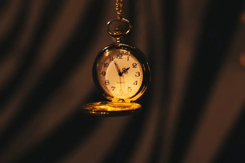 A gold pocket watch hanging from a chain
