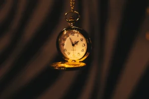 A gold pocket watch hanging from a chain