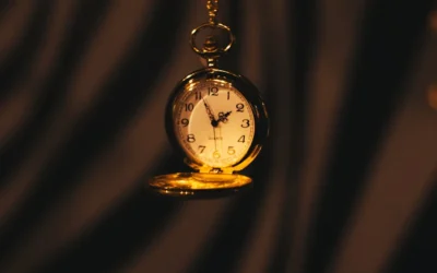 A gold pocket watch hanging from a chain