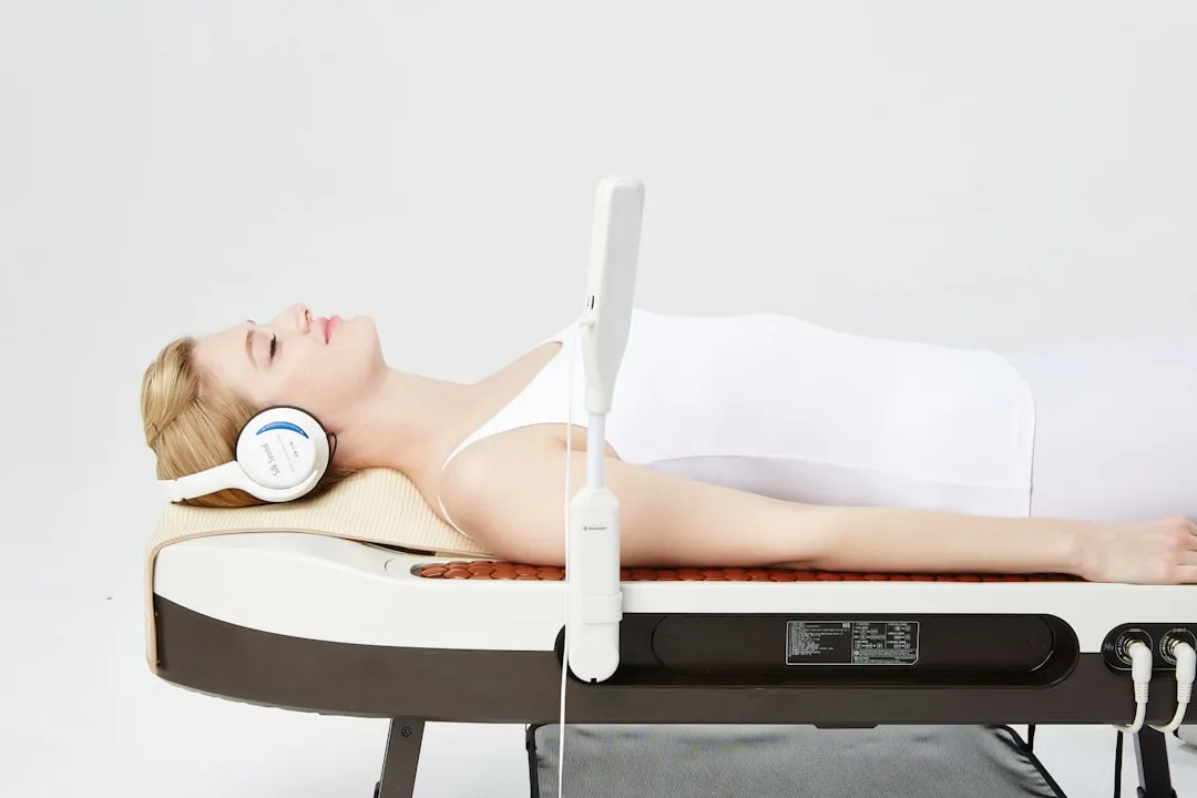 a woman laying on a bed with headphones on