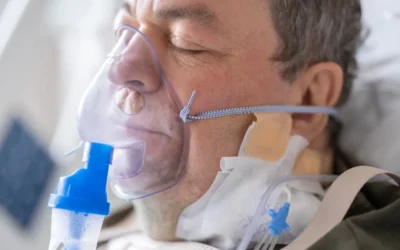 a man laying in a hospital bed with an oxygen tube attached to his face