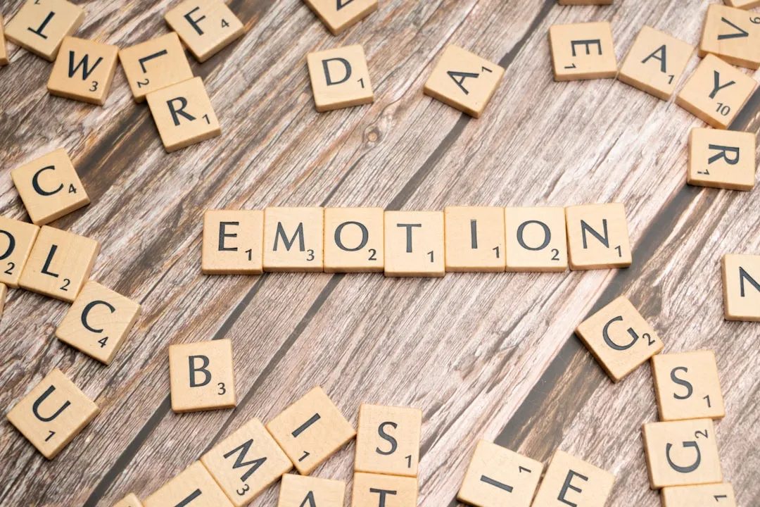 scrabble tiles spelling the word emotion on a wooden surface