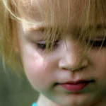 blonde haired toddler looking down