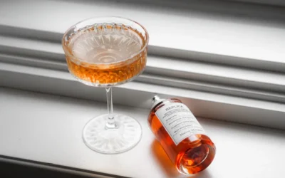 a bottle of alcohol sitting next to a wine glass