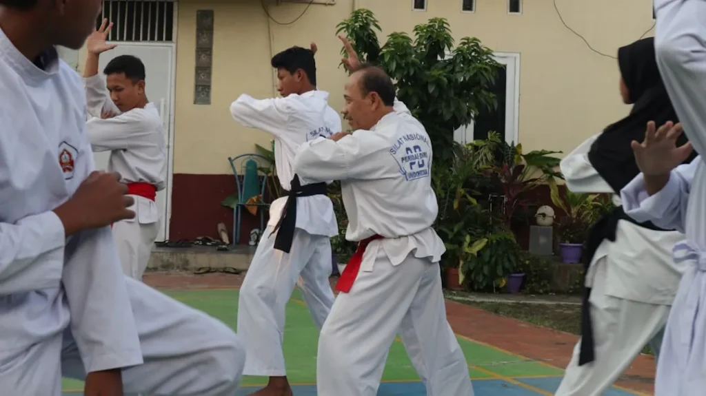 A group of men practicing karate in front of a building