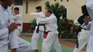 A group of men practicing karate in front of a building
