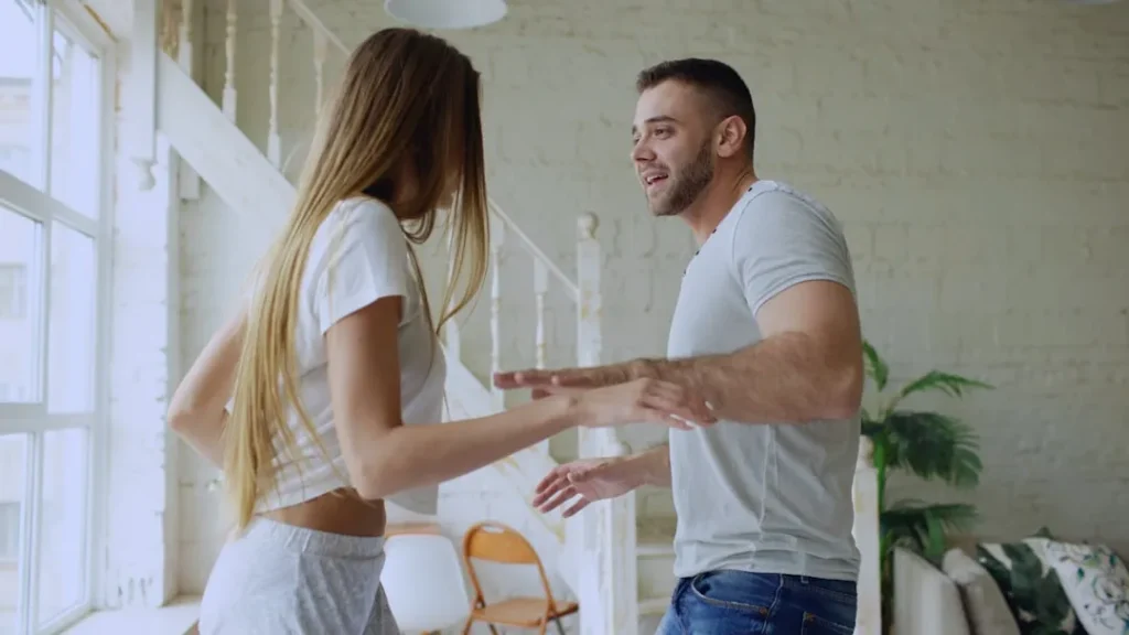 Couple dancing together in a bright room.