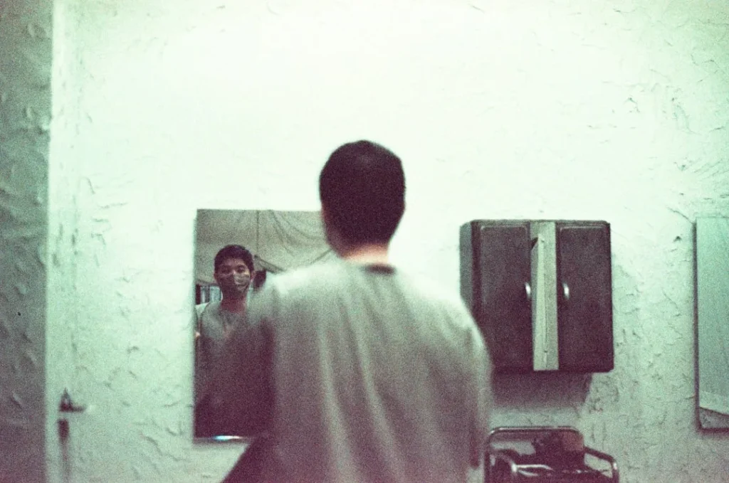 a man standing in front of a mirror in a bathroom