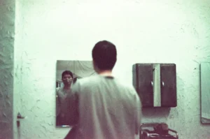 a man standing in front of a mirror in a bathroom