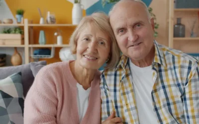 Elderly couple smiling together on a couch.