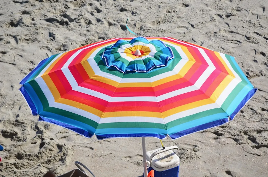 A colorful umbrella sitting on top of a sandy beach