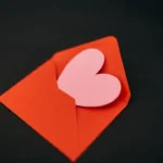 a red envelope with a heart cut out of it