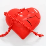 A broken red heart with a rope attached to it