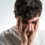 man touching face with both hands