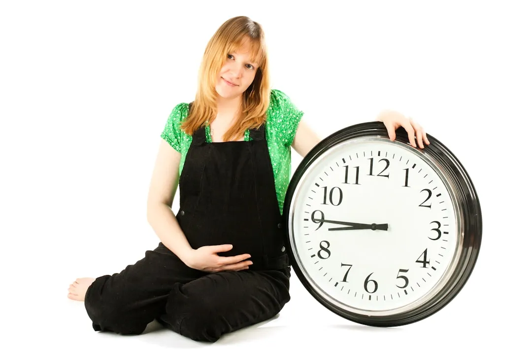 A woman sitting on the floor holding a clock