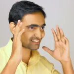 a man is smiling and making a hand gesture