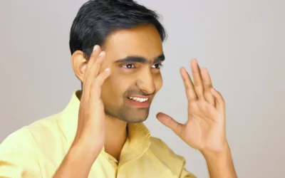 a man is smiling and making a hand gesture