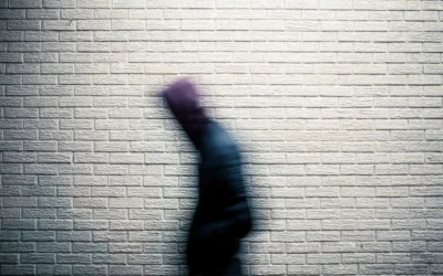 a blurry image of a person standing in front of a brick wall