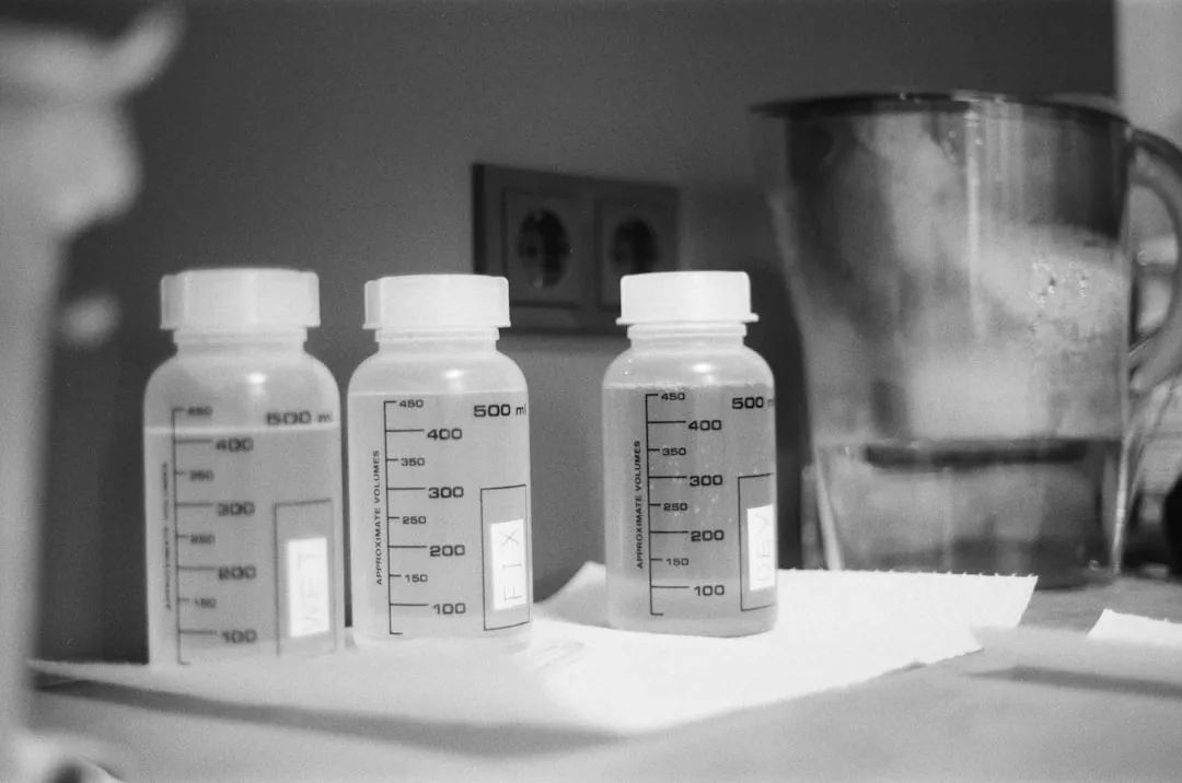 three bottles of liquid sitting on top of a counter