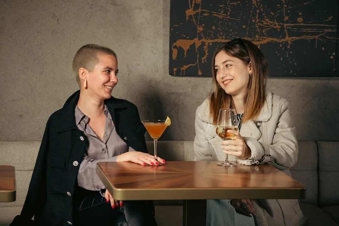 a man and a woman sitting at a table with drinks
