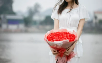 a woman holding a bouquet of red roses