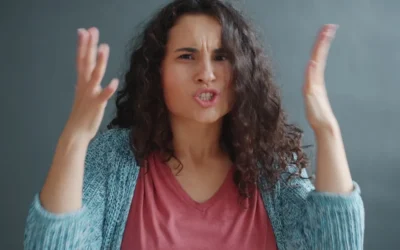 Woman with curly hair looking angry and frustrated.