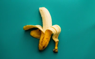 a peeled banana sitting on top of a blue surface