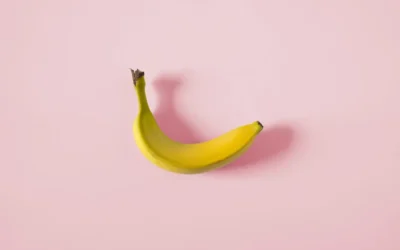 A single banana on a pink background
