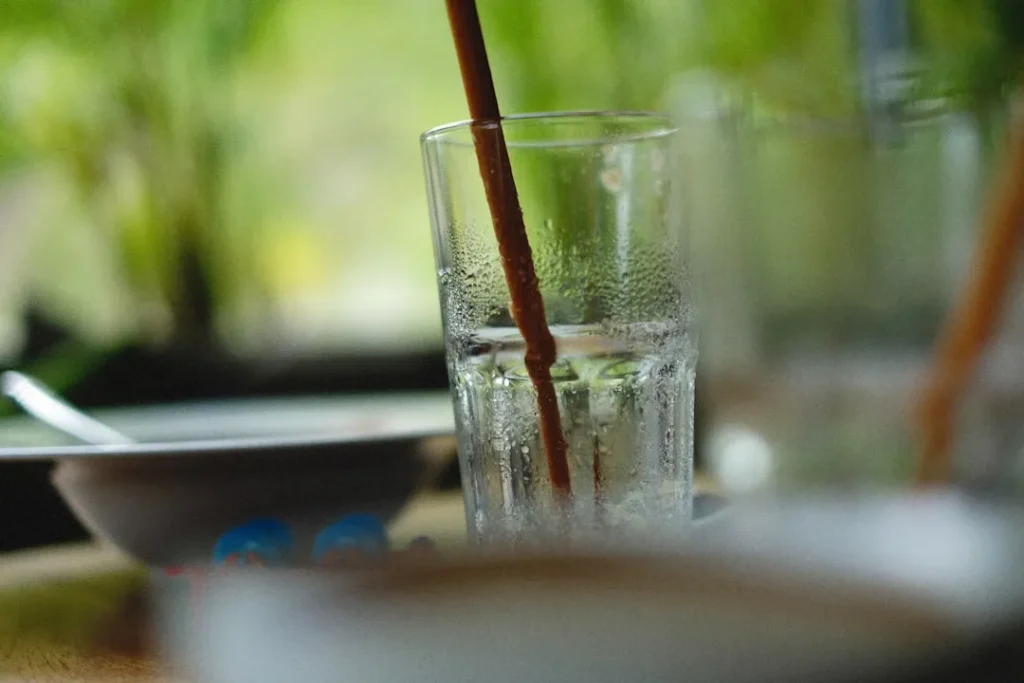 a close up of a glass of water with a straw sticking out of it