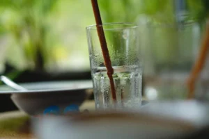 a close up of a glass of water with a straw sticking out of it