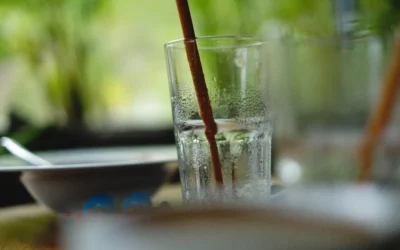 a close up of a glass of water with a straw sticking out of it