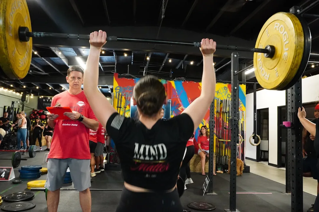 Woman performs a heavy overhead weight lift.